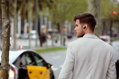 Зображення чоловіка, що йде вулицею в навушниках WF-1000XM3